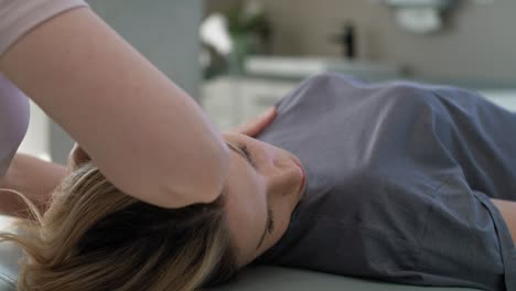 una fisioterapeuta masajeando a su paciente.