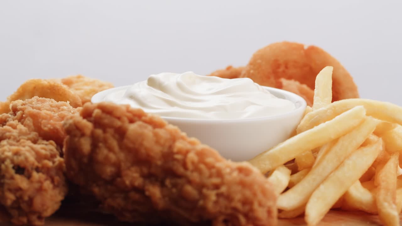 pollo frito, patatas fritas, anillos de cebolla y salsa