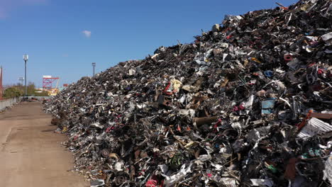 footage alongside a large pile of scrap metal waiting to be loaded onto a ship for recycling