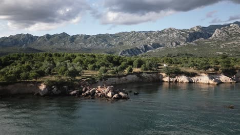 beatiful stone coast of an ocean with big mountains in the background on goldon hour