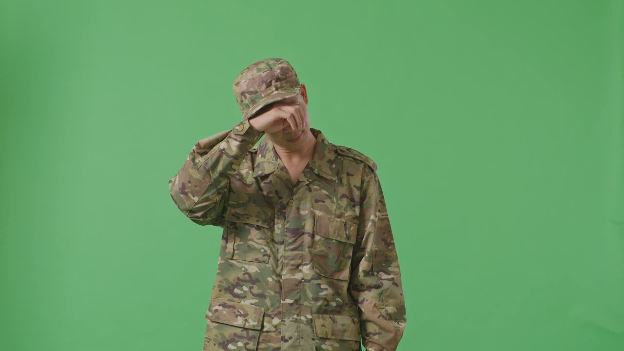 Asian Man Soldier Wiping The Sweat And Being Tired While Standing In The Green Screen Background Studio