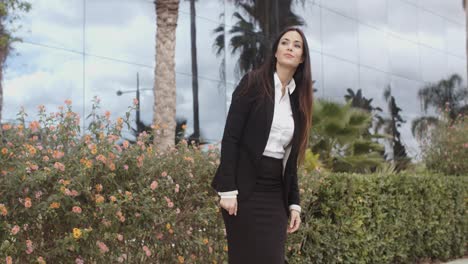 una elegante mujer de negocios de pie fuera de su oficina.
