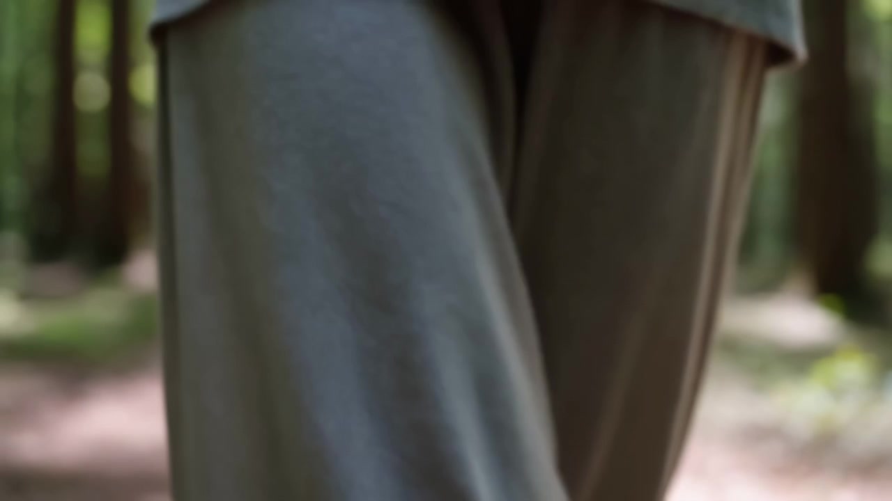 Tight close-up of two adjacent fabric panels or pant legs with left panel cool gray-blue and right panel warm tan-brown