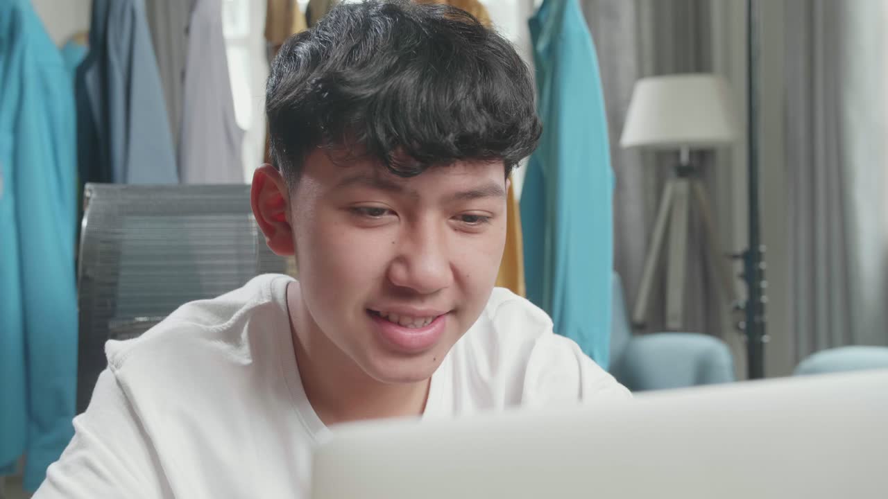 Teenager using laptop at home