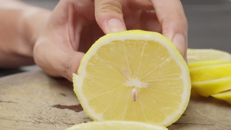 cutting a piece of lemon on board with a large knife