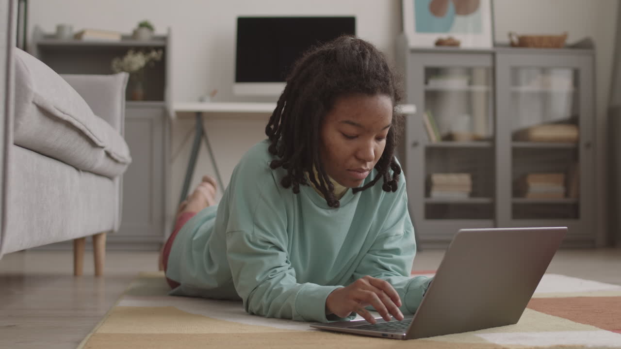 Female African Student Using Laptop at Home