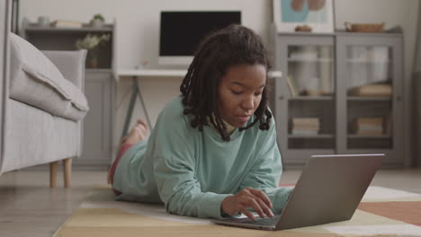 female african student using laptop at home