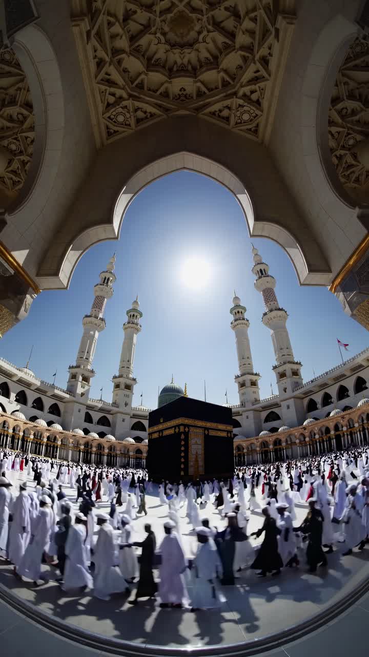 Fisheye lens captures a dynamic video scene of pilgrims circling the Kaaba, framed by an arch