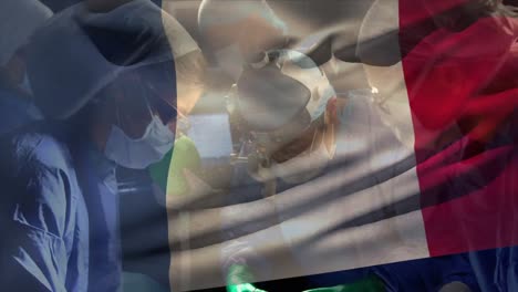 Animation-of-flag-of-france-over-diverse-surgeons-with-face-masks-during-surgery