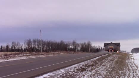 slomo of a house being moved by truck down a highway in the winter