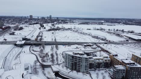 Vista-Aérea-Del-Paisaje-Cubierto-De-Nieve-En-La-Ciudad-De-Ottawa-En-Canadá-Con-Tráfico-En-La-Carretera-En-Invierno