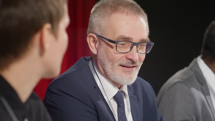 Seniorpolitiker taler med kollega på pressemøde