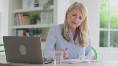 Mujer-Madura-Menopáusica-Olvidadiza-Trabajando-En-Una-Computadora-Portátil-En-Casa-Tratando-De-Recordar