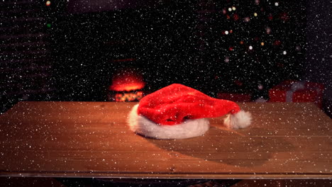 Video-composition-with-falling-snow-over-desk-with-santas-hat