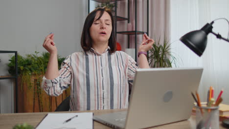 tired woman freelancer suffering from headache migaine , closing eyes meditating at home office