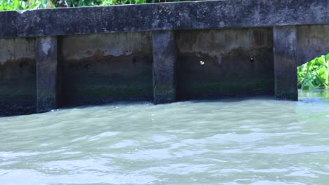 el agua fluye bajo un puente en bangkok.
