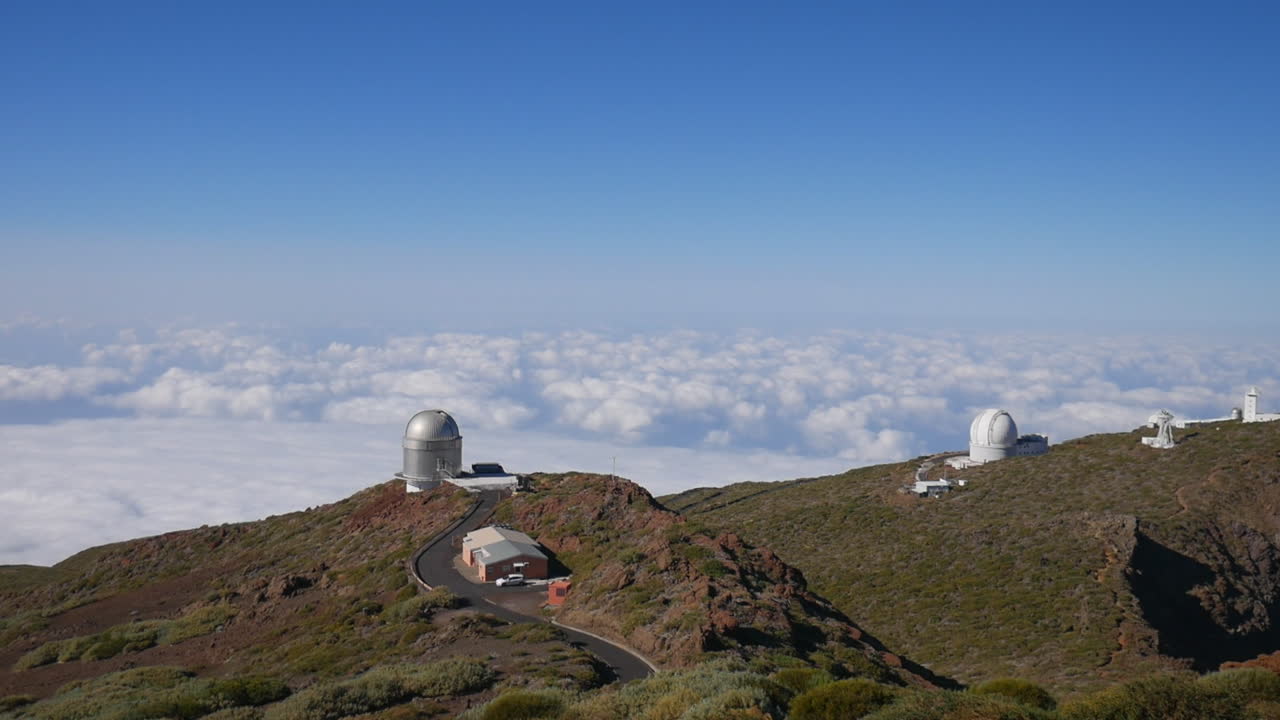 Telescopes of the Roque de los Muchachos Observatory on La Palma island above a sea of clouds