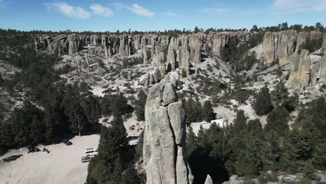 Luftdrohne-Fliegt-über-Dem-Indigenen-Steindenkmal-Creel-Monk-Stone-Valley-Mexiko-Reiseziel-Im-Trockenen-Sommer,-Chihuahua-Gebirge,-Dunkelgrüne-Bäume-Und-Skyline