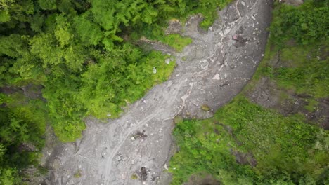 Vista-Aérea,-Flujo-De-Río-De-Lava-Fría-Del-Monte-Merapi-Y-Camiones-Visibles-Y-Mineros-De-Arena-En-Movimiento