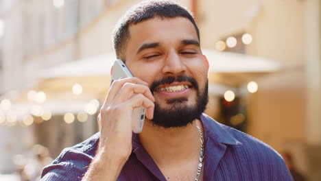 man talking on phone outside cafe