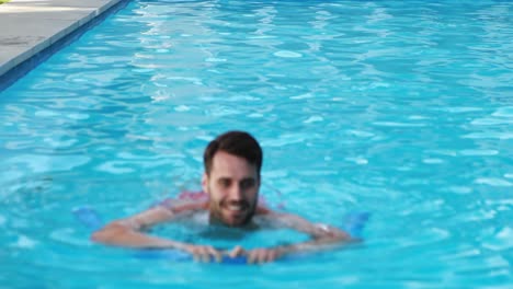 man swimming with inflatable tube in the pool