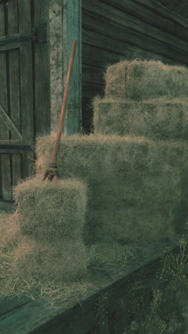 hay bales in front of a barn