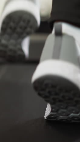 mujer hace ejercicios usando cinta de correr de cerca. mujer en forma activa con zapatos deportivos participa en el jogging en el dispositivo de entrenamiento interior vista superior cámara lenta