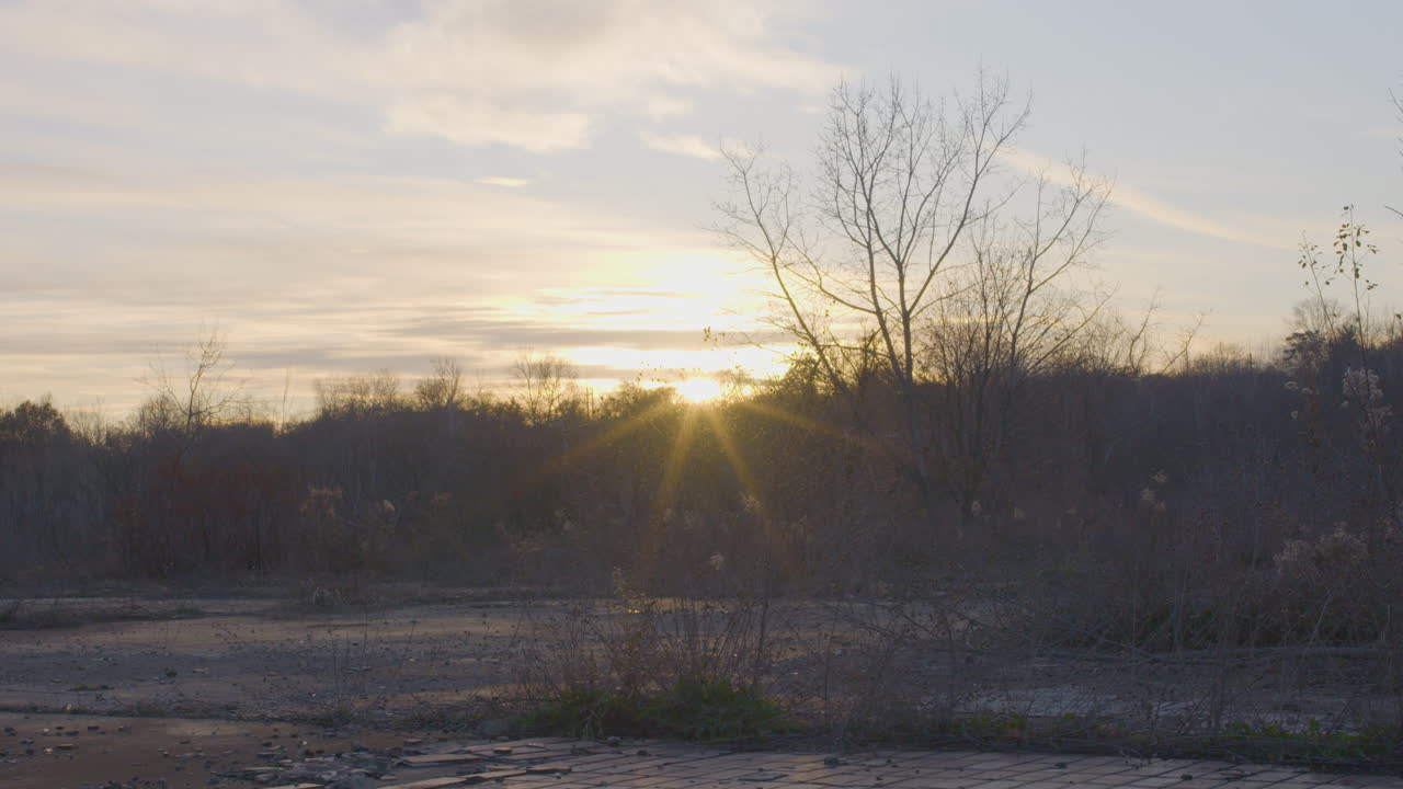 오하이오 의 버려진 산업 공원 에 있는 언덕 뒤 에 해 가 지는 것