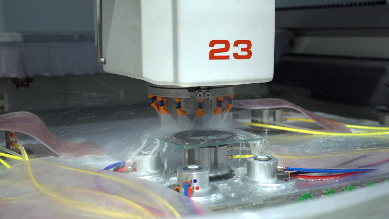 máquina cnc con un sistema de refrigeración por agua que muele los bordes de una pequeña placa de vidrio