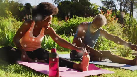 animation of light spots over african american couple doing yoga, stretching, slow motion