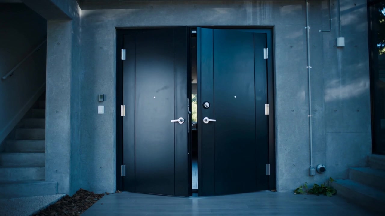 Closing double black doors from open to closed at entrance, with hydraulic closers securing entry