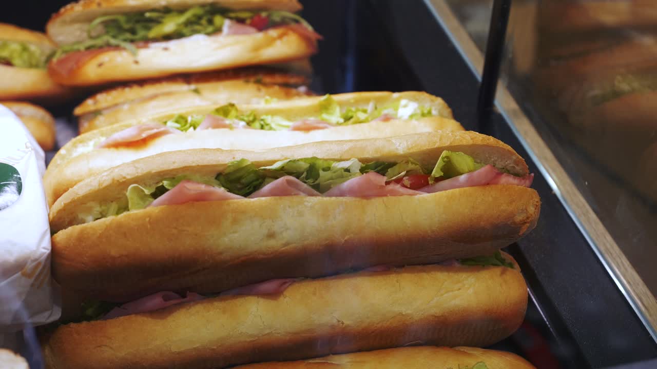 sándwich con jamón y lechuga exhibido detrás de la ventana de una tienda local