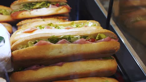 sandwich with ham and lettuce displayed behind the window of a local shop