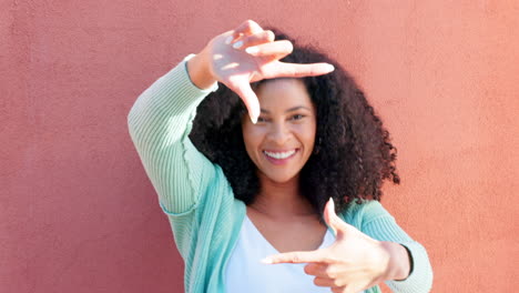 Happy-black-model,-funny-frame-face-on-wall