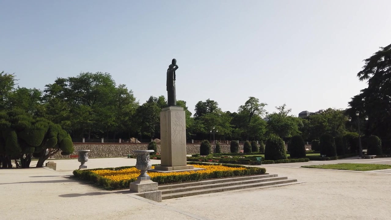 Madrid Spagna Panoramica Lenta del Giardino del Parterre del Parco del Retiro, Monumento a Jacinto Benavente e Aiuole di Fiori Gialli.