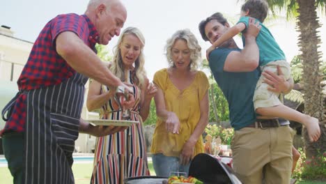 Happy-caucasian-family-having-barbecue-and-eating-in-garden