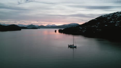 Panoramic-drone-shot-circling-a-sailing-boat-anchored-in-middle-island-in-Alaska