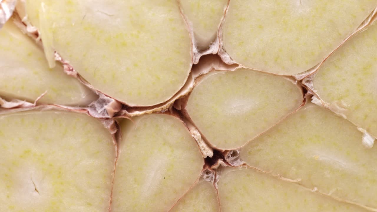 Uncovering a bunch of garlic cloves cut in half. Macro close-up