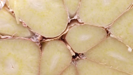 uncovering a bunch of garlic cloves cut in half. macro close-up
