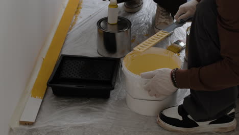 person painting a wall yellow