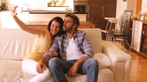 couple relaxing on sofa and taking a selfie