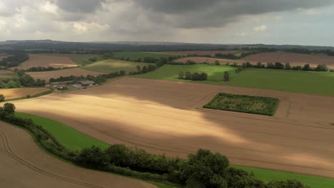 stormy threatening rain clouds casting shadows across devizes agricultural farmland aerial view