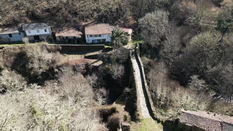 Aerial-pullback-above-old-historic-Roman-bridge-crossing-Navea-River