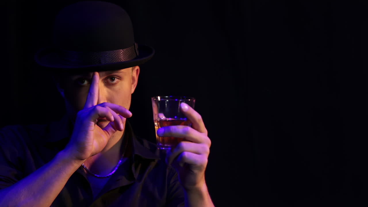 어두운 환경에서 위스키를 마신 남자