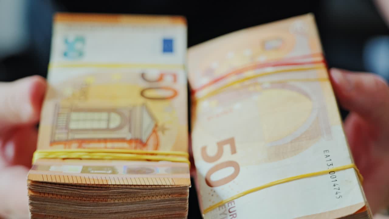 Nærbillede af hænder, der holder en stak eurosedler, organiseret kriminalitet og ulovlig handel