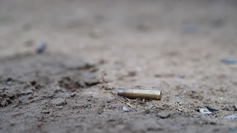 Empty-cartridge-without-projectile-on-ground,-blank-bullet-at-shooting-range