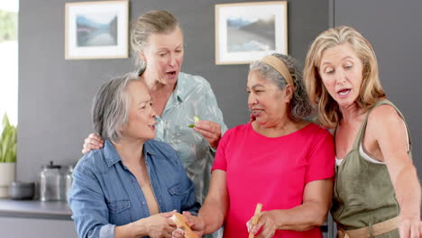 Grupo-Diverso-De-Mujeres-Mayores-Preparando-Una-Comida-Juntas-En-Casa,-Seguida-De-Una-Ensalada