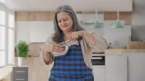 Happy-Indian-aged-housewife-making-food