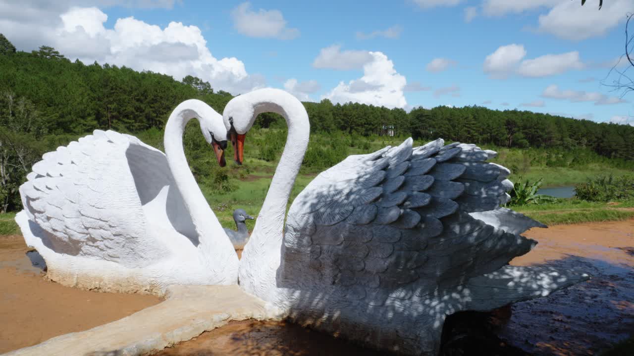 목이 하트 모양으로 구부러진 두 마리의 백조의 점토 조각