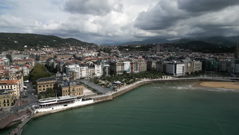 Drone-Shot-Coming-Down-on-an-Ocean-Promenade-in-San-Sebastian,-Spain